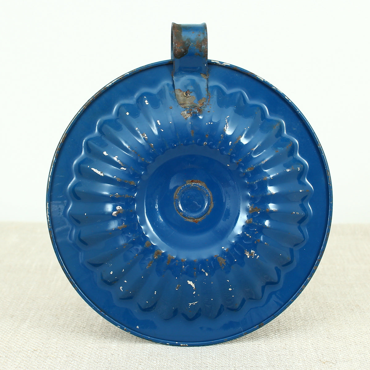 A vintage blue metal chamberstick/candle holder, simple loop handle, 16cm diameter