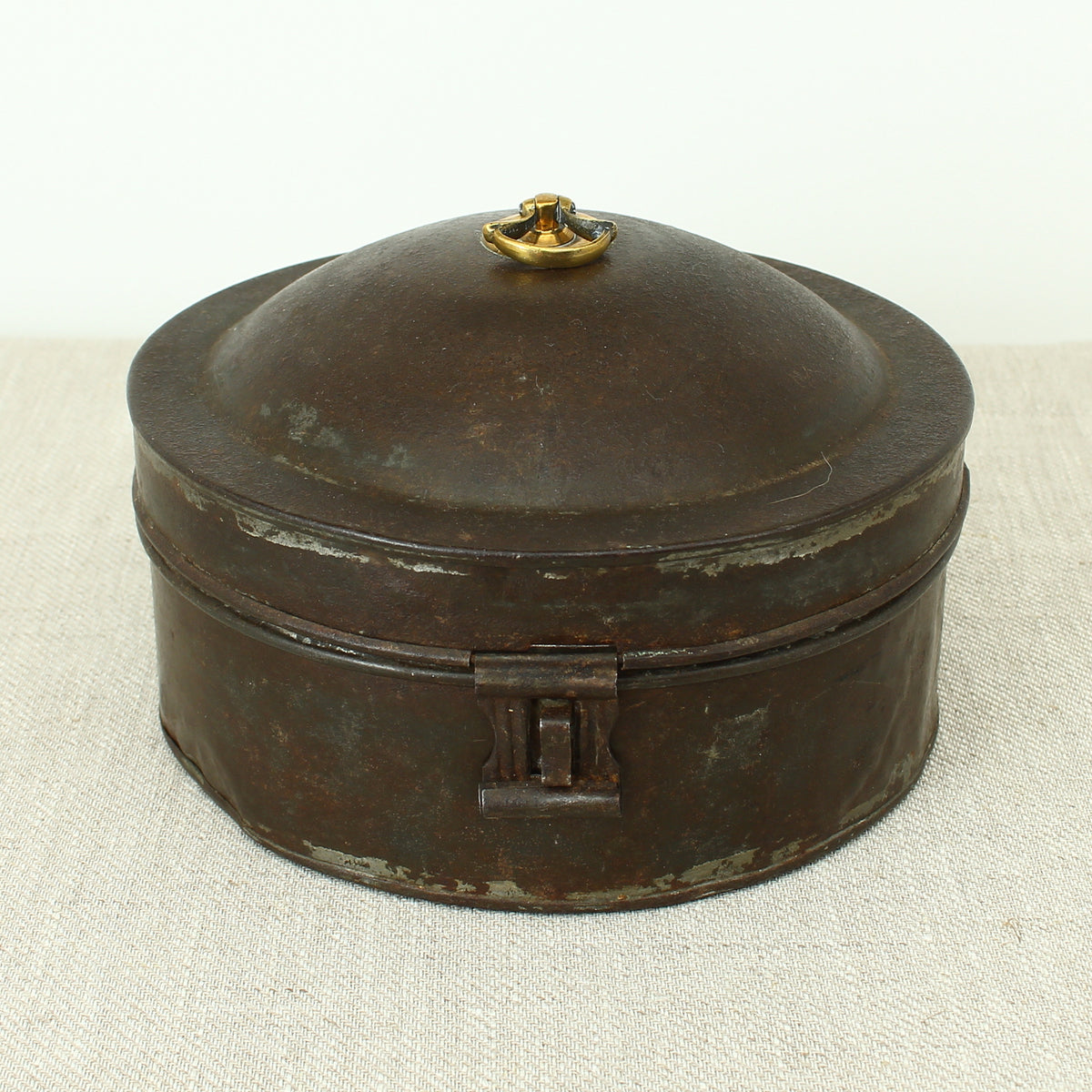 A 19th century metal circular spice tin, the fitted interior with sectional divides, domed lid with brass ring handle, metal clasp, 11cm high, 17cm diameter