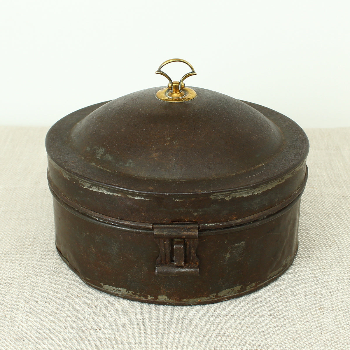 A 19th century metal circular spice tin, the fitted interior with sectional divides, domed lid with brass ring handle, metal clasp, 11cm high, 17cm diameter