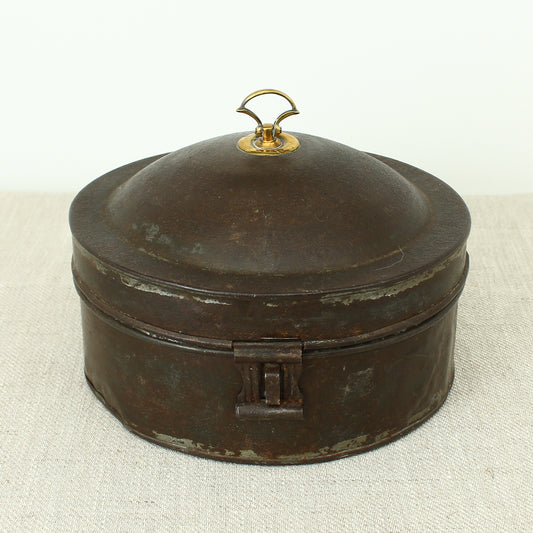 A 19th century metal circular spice tin, the fitted interior with sectional divides, domed lid with brass ring handle, metal clasp, 11cm high, 17cm diameter