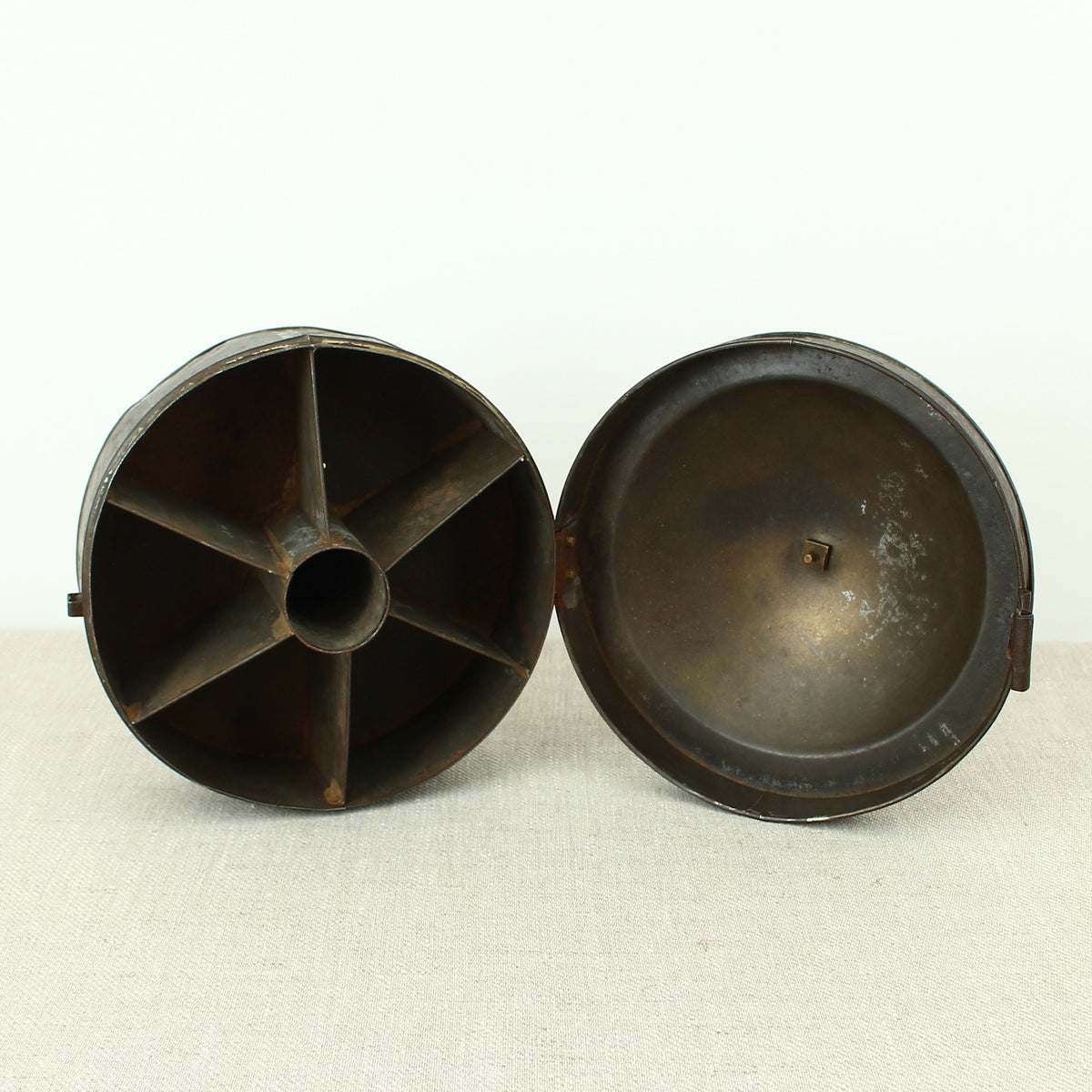 A 19th century metal circular spice tin, the fitted interior with sectional divides, domed lid with brass ring handle, metal clasp, 11cm high, 17cm diameter