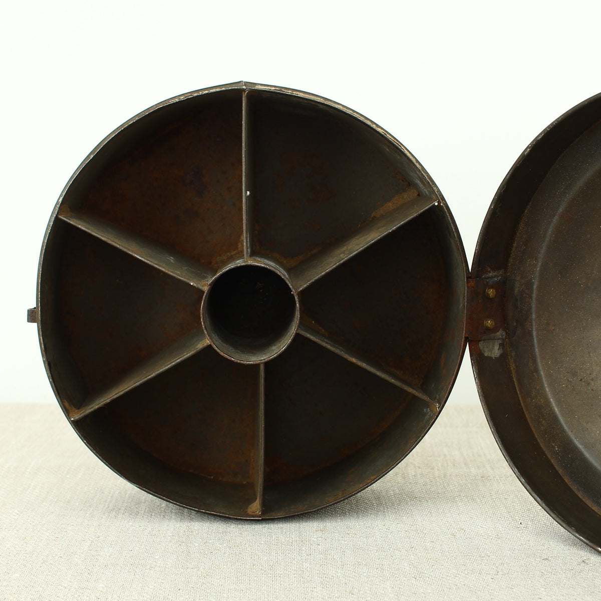 A 19th century metal circular spice tin, the fitted interior with sectional divides, domed lid with brass ring handle, metal clasp, 11cm high, 17cm diameter