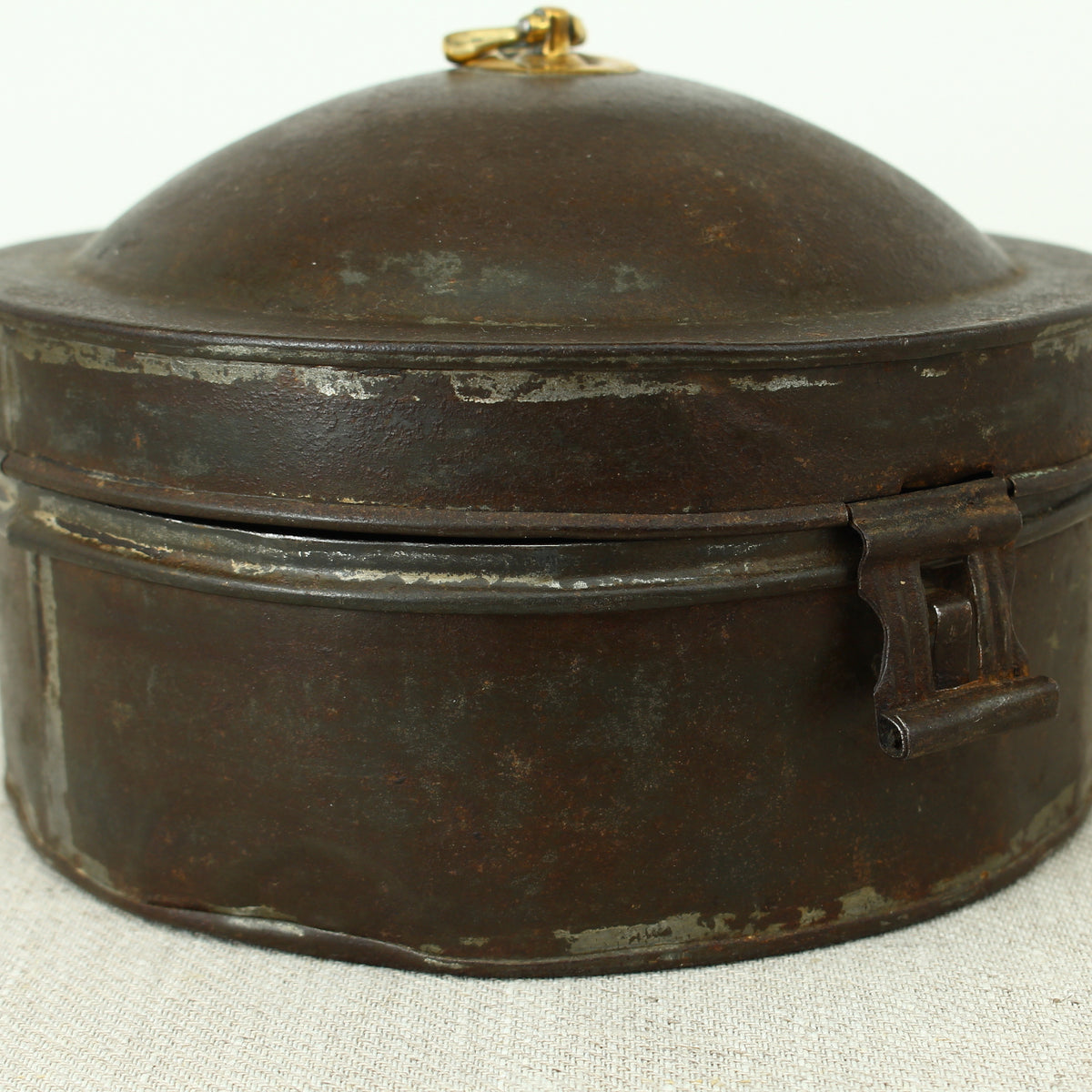 A 19th century metal circular spice tin, the fitted interior with sectional divides, domed lid with brass ring handle, metal clasp, 11cm high, 17cm diameter