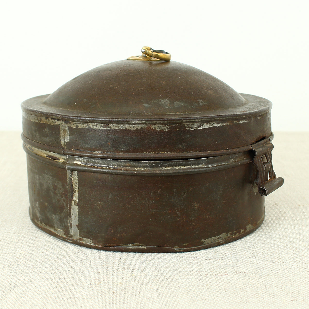 A 19th century metal circular spice tin, the fitted interior with sectional divides, domed lid with brass ring handle, metal clasp, 11cm high, 17cm diameter