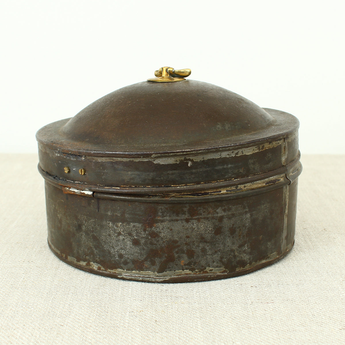 A 19th century metal circular spice tin, the fitted interior with sectional divides, domed lid with brass ring handle, metal clasp, 11cm high, 17cm diameter
