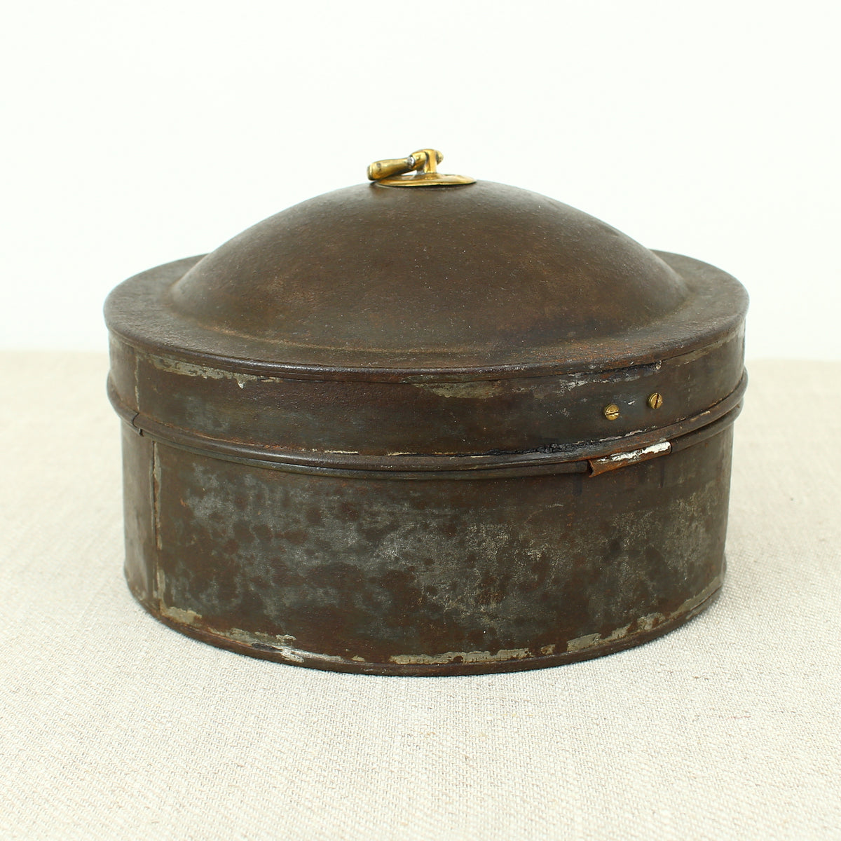 A 19th century metal circular spice tin, the fitted interior with sectional divides, domed lid with brass ring handle, metal clasp, 11cm high, 17cm diameter