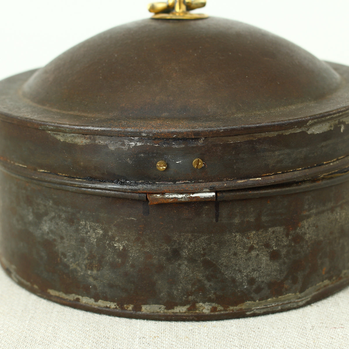 A 19th century metal circular spice tin, the fitted interior with sectional divides, domed lid with brass ring handle, metal clasp, 11cm high, 17cm diameter