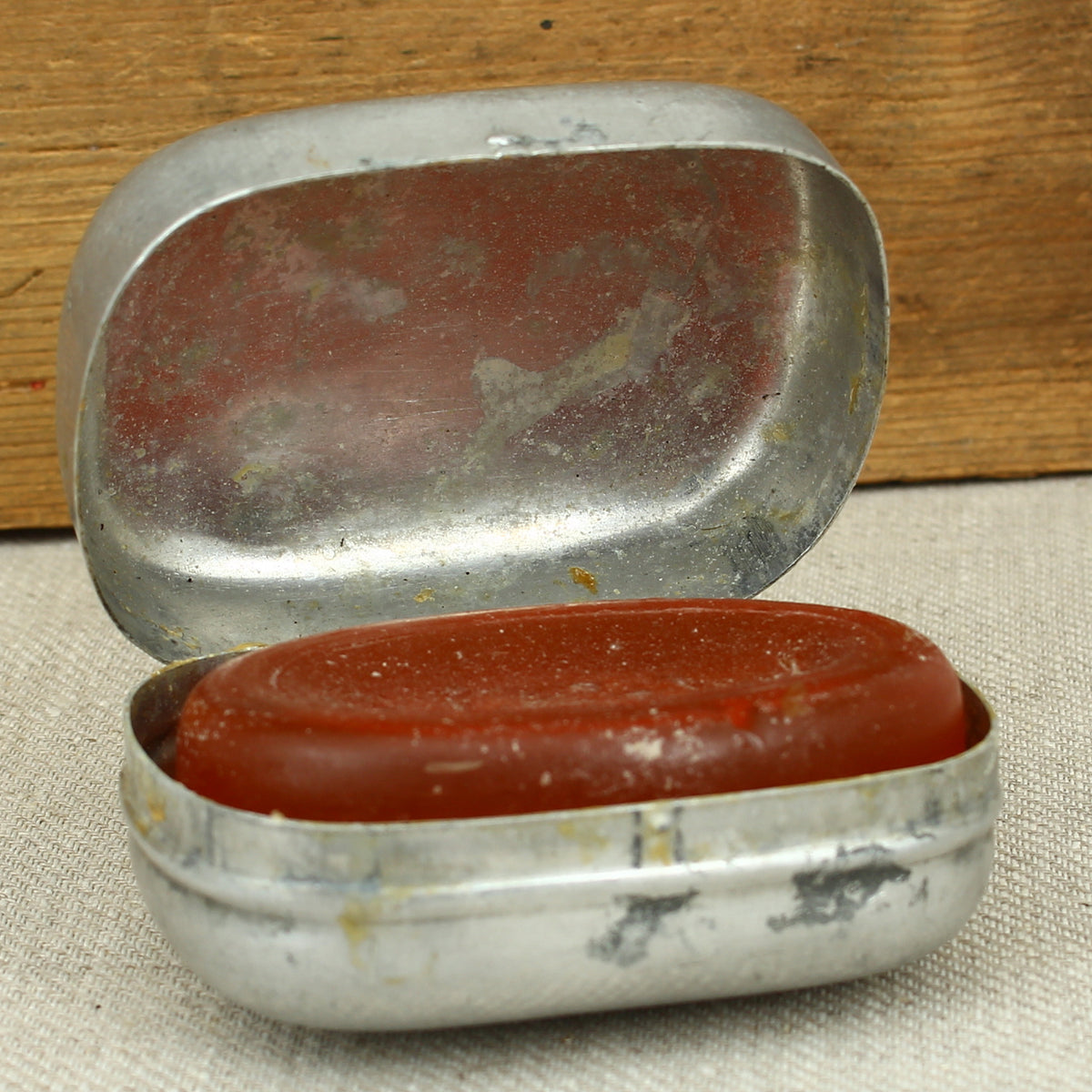 A World War II British Army aluminium soap tin, impressed marks 'W.S.L., 1945, (Broad Arrow), CC 1114'