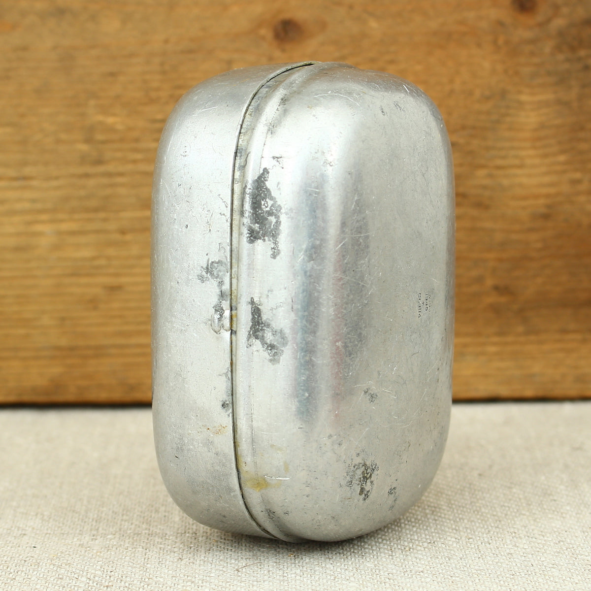 A World War II British Army aluminium soap tin, impressed marks 'W.S.L., 1945, (Broad Arrow), CC 1114'
