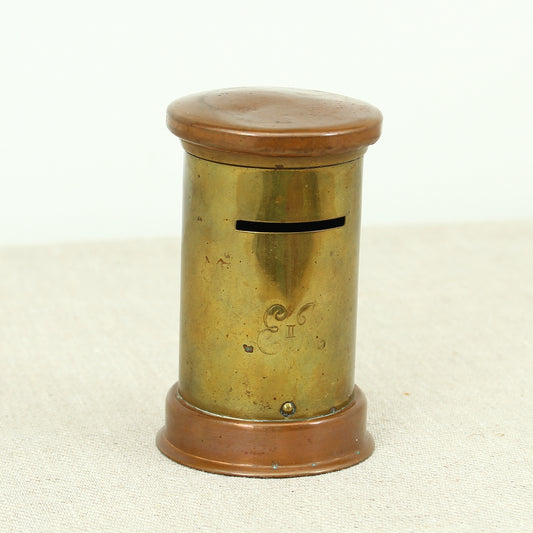 A vintage brass and copper novelty money box or money bank, in the form of a British pillar box