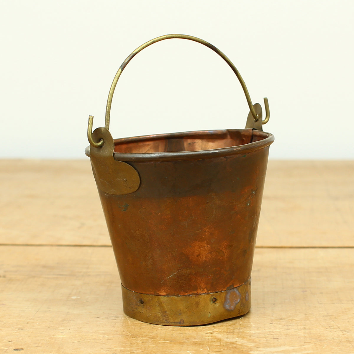 A collection of four early 20th century copper and brass miniature buckets