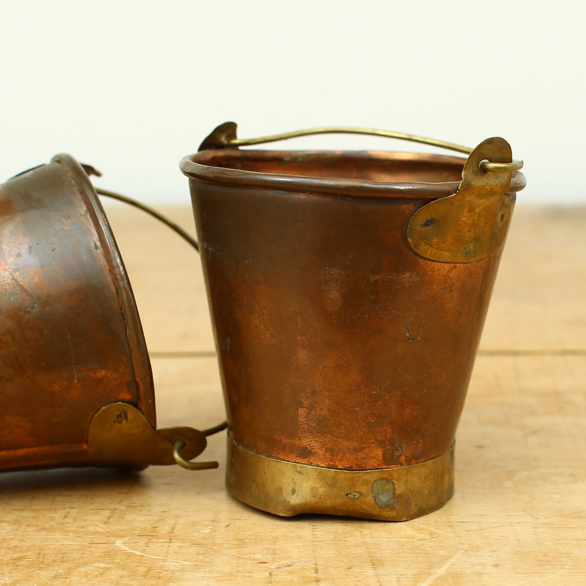 A collection of four early 20th century copper and brass miniature buckets
