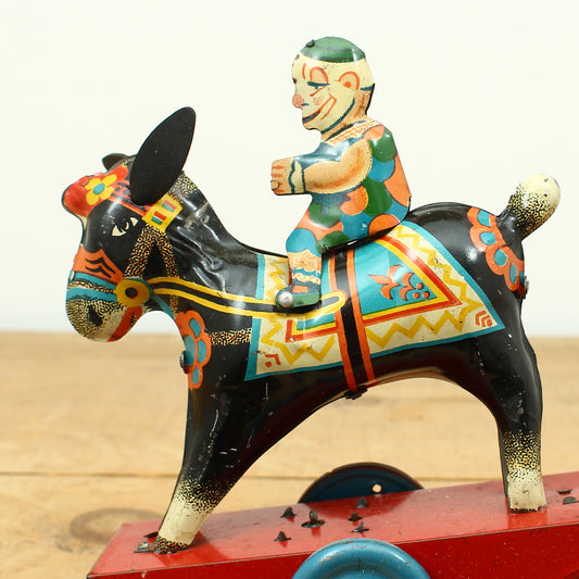 Toys & Juvenalia - a novelty tinplate and fixed clockwork mechanical toy, of a clown riding a Donkey