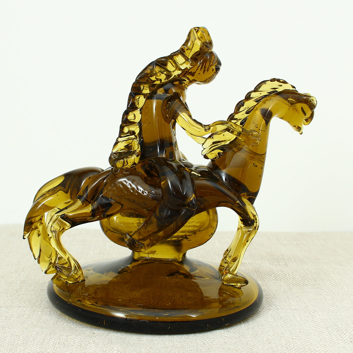 Art Glass & Mid 20th Century Design - an amber glass novelty sculpture, in the form of a Native American Indian riding a Horse with headdress, 20cm high, circular base with pontil marks to underside of base