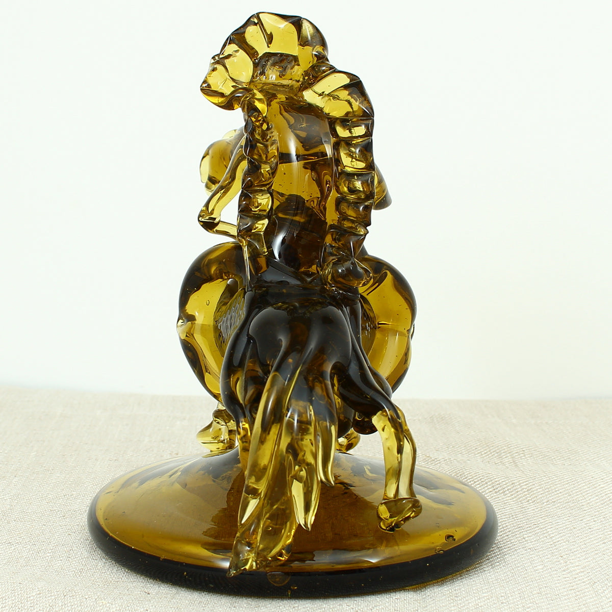 Art Glass & Mid 20th Century Design - an amber glass novelty sculpture, in the form of a Native American Indian riding a Horse with headdress, 20cm high, circular base with pontil marks to underside of base