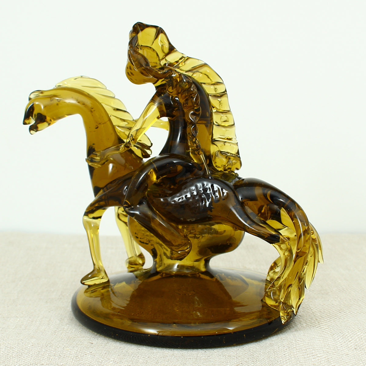 Art Glass & Mid 20th Century Design - an amber glass novelty sculpture, in the form of a Native American Indian riding a Horse with headdress, 20cm high, circular base with pontil marks to underside of base