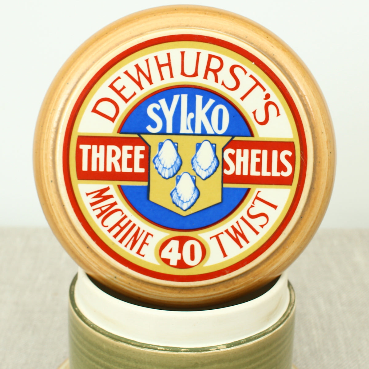 Advertising & Haberdashery Interest - a novelty ceramic jar, in the form of a faux oversized cotton reel, press close cover with printed design, 'DEWHURST'S SYLKO THREE SHELLS, MACHINE TWIST 40', finished in green, 15.5cm high