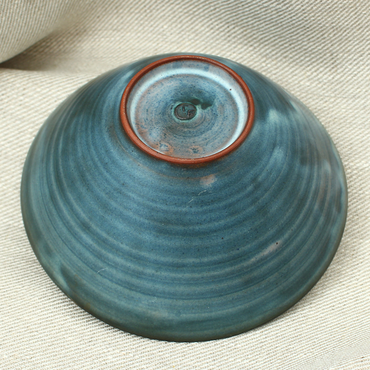Tessa Fuch (British 1936-2012), matte glazed bowl, decorated with a sunrise design in blue and yellow tones, 16cm diameter, impressed initials to base