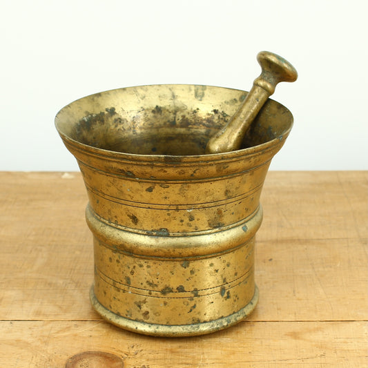 A 19th century bronze mortar and pestle, cylindrical form with girdle and everted rim