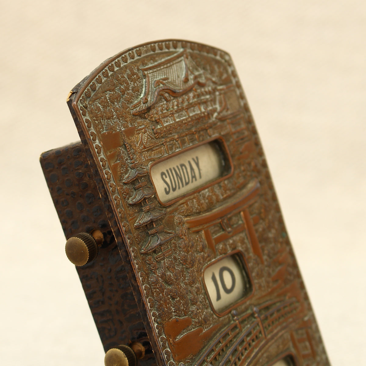 An early 20th century Japanese perpetual desk calendar, the cast metal face plate probably manufactured from antimony or a similar alloy